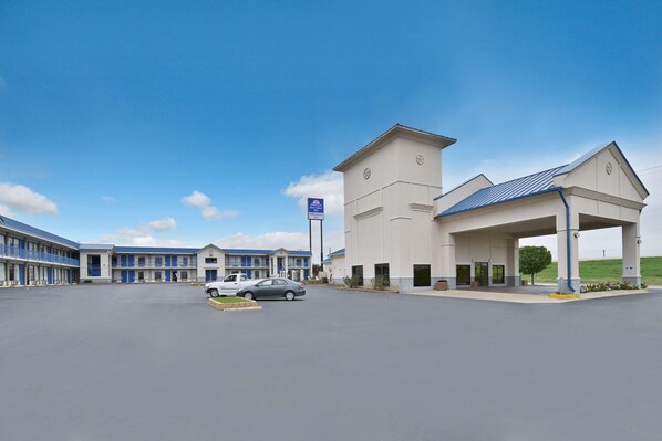 A hotel with a central building and a covered parking area. - Americas Best Value Inn Hillsboro (Hillsboro)