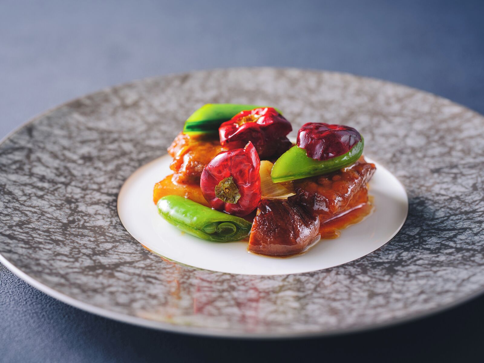 A plate of food with a textured, dark-colored plate.