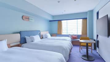 A hotel room with two beds, a small table, a chair, a TV, and a window with curtains.
