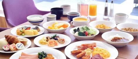 Um buffet de café da manhã com diversos pratos, bebidas e acompanhamentos.