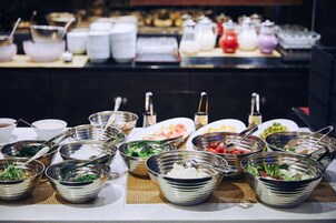 A buffet with various dishes and utensils.