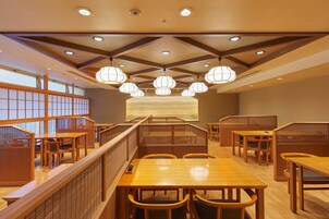 A traditional Japanese-style restaurant interior with wooden furniture, tatami mats, and shoji screens.