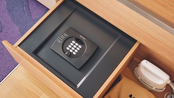 A drawer with a black device, a white phone, and a brown bag with a logo.