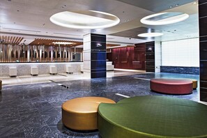 Eine moderne Lobby mit Empfangstresen, Sitzbereichen und einem Marmorboden.