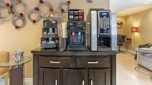 A coffee station with a coffee machine, a water dispenser, and a cash box.