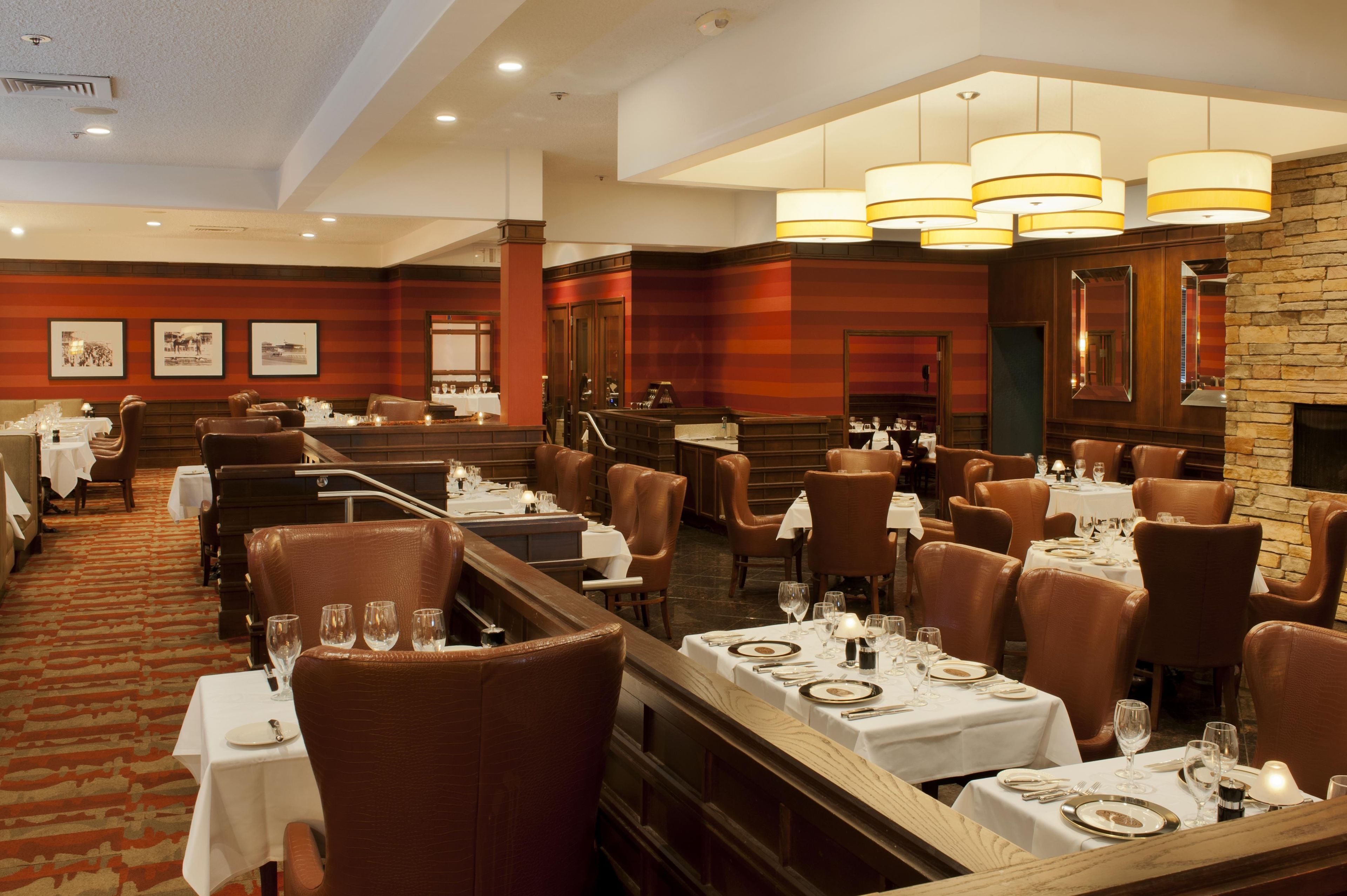 A restaurant with multiple dining tables, chairs, and a fireplace.