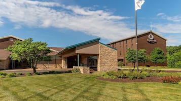 Experience the hotel's modern design, featuring a covered patio entrance and beautifully maintained grounds.
