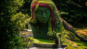 Una estatua de jardín con una cascada.