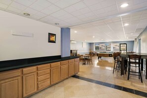 Amplio espacio interior con mesa de billar, mesas y sillas de comedor.