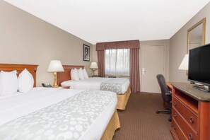 A hotel room with two beds, a desk, a chair, a television, and a window with curtains. - Days Inn by Wyndham St Augustine/Historic Downtown (St. Augustine)