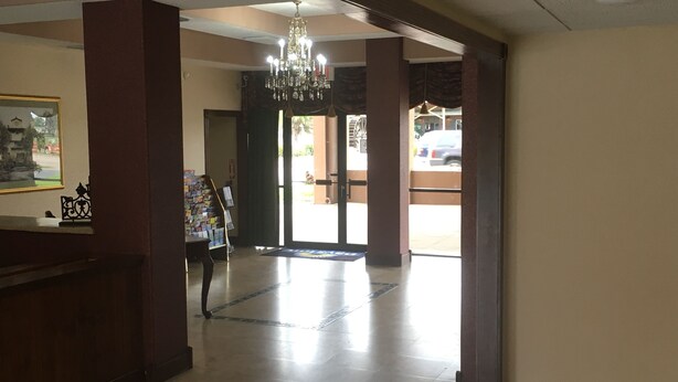 A spacious lobby with a chandelier, a reception desk, and a view of the outside. - Days Inn by Wyndham St Augustine/Historic Downtown (St. Augustine)