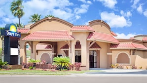 A hotel with a Days Inn sign, featuring a Mediterranean architectural style with red-tiled roofs and arched doorways. - Days Inn by Wyndham St Augustine/Historic Downtown (St. Augustine)