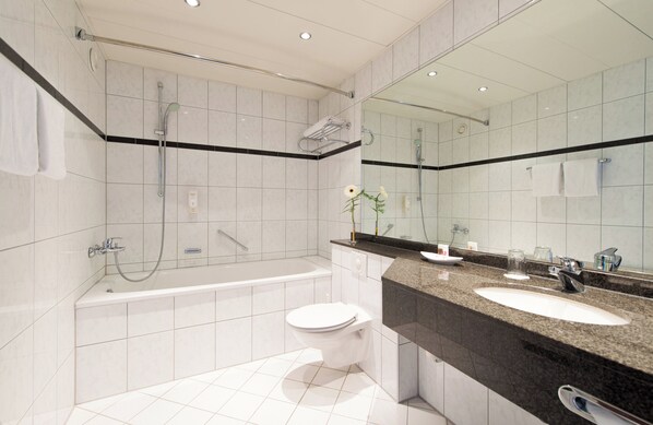 A modern bathroom with a bathtub, toilet, and sink.
