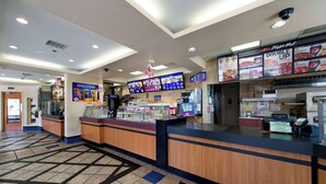 A pizza restaurant interior with a counter, menu boards, and a tiled floor. - Howard Johnson Plaza by Wyndham by the Falls Niagara Falls (Niagara Falls)