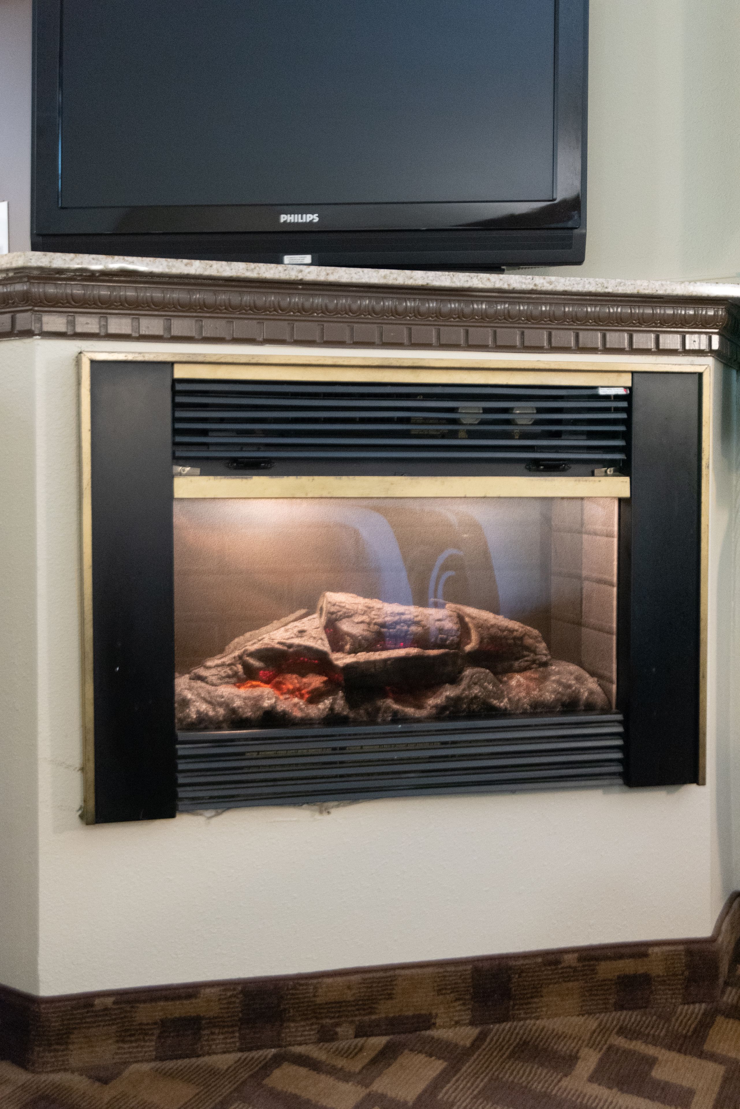 A fireplace with a television mounted above it.
