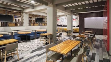 A modern restaurant with booths, tables, and a bar area.