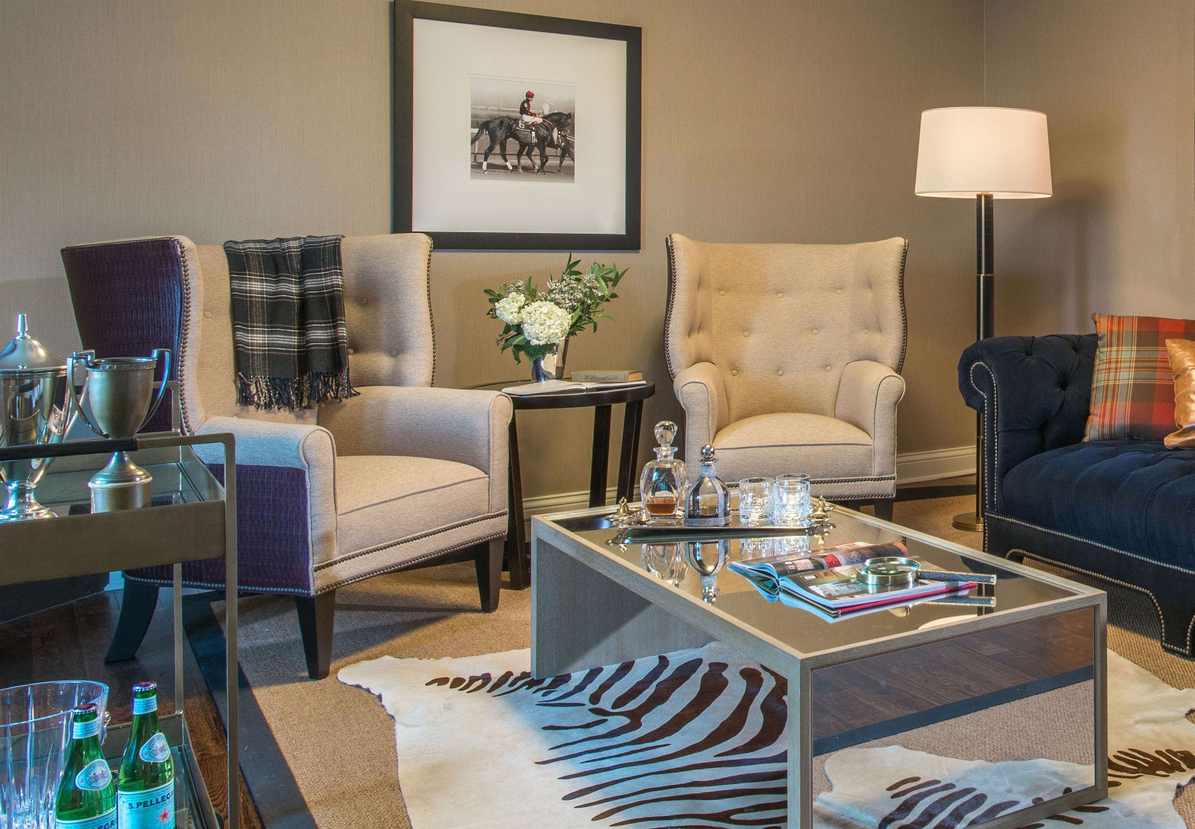 A well-appointed living room with a sofa, armchairs, a coffee table, and a lamp.