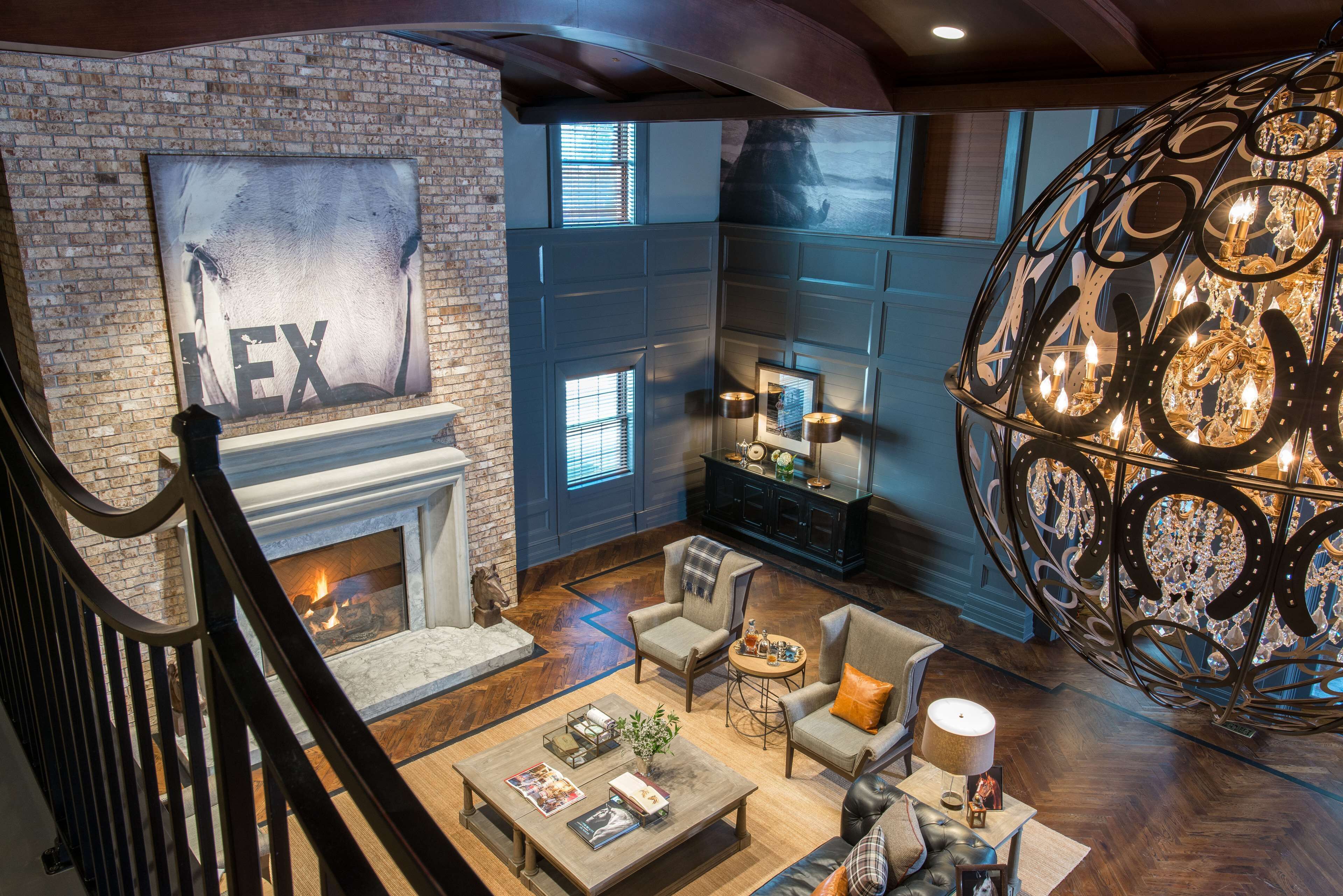 A spacious living room with a fireplace, comfortable seating, and a decorative chandelier.