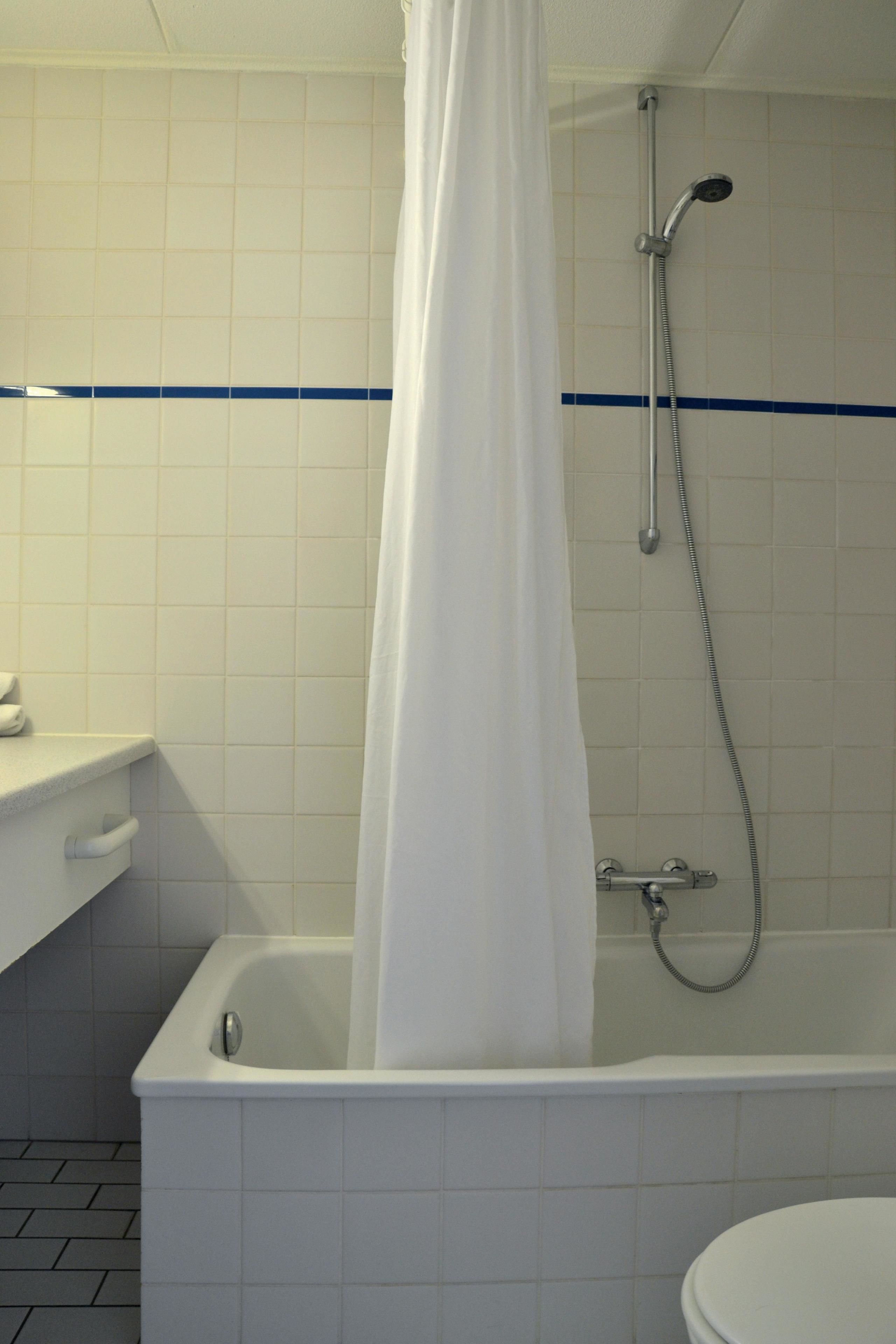 Un baño con bañera, ducha e inodoro.