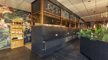 Ein Restaurantinneres mit schwarzer Außenfassade, Holzdetails und einer Tafelnennkarte.
