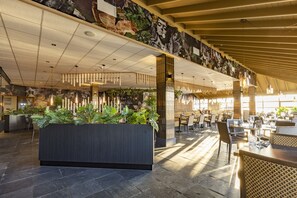 A spacious lobby with a reception desk, seating area, and a high ceiling with hanging lights. - Fletcher Hotel Callantsoog (Callantsoog)