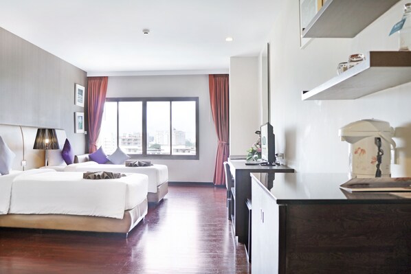 A hotel room with a large bed, a desk, and a view of the city.