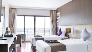 A hotel room with two beds, a desk, and a view of the city. - Mida Hotel Don Mueang Airport (Bangkok)