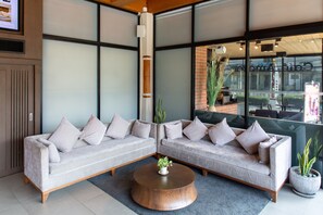 A modern living room with two sofas, a coffee table, and a large window with a view of the outside.