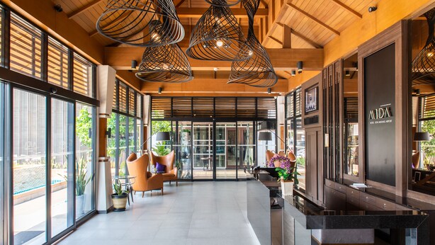 A spacious lobby with modern lighting fixtures, large windows, and a reception desk. - Mida Hotel Don Mueang Airport (Bangkok)