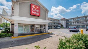 Un hotel llamado Econo Lodge con un letrero grande, un estacionamiento y un edificio de varios pisos.