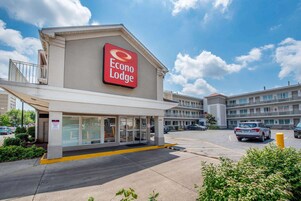 Un hotel llamado Econo Lodge con un letrero grande, un estacionamiento y un edificio de varios pisos.