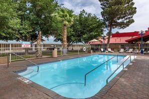 Una piscina al aire libre, tumbonas