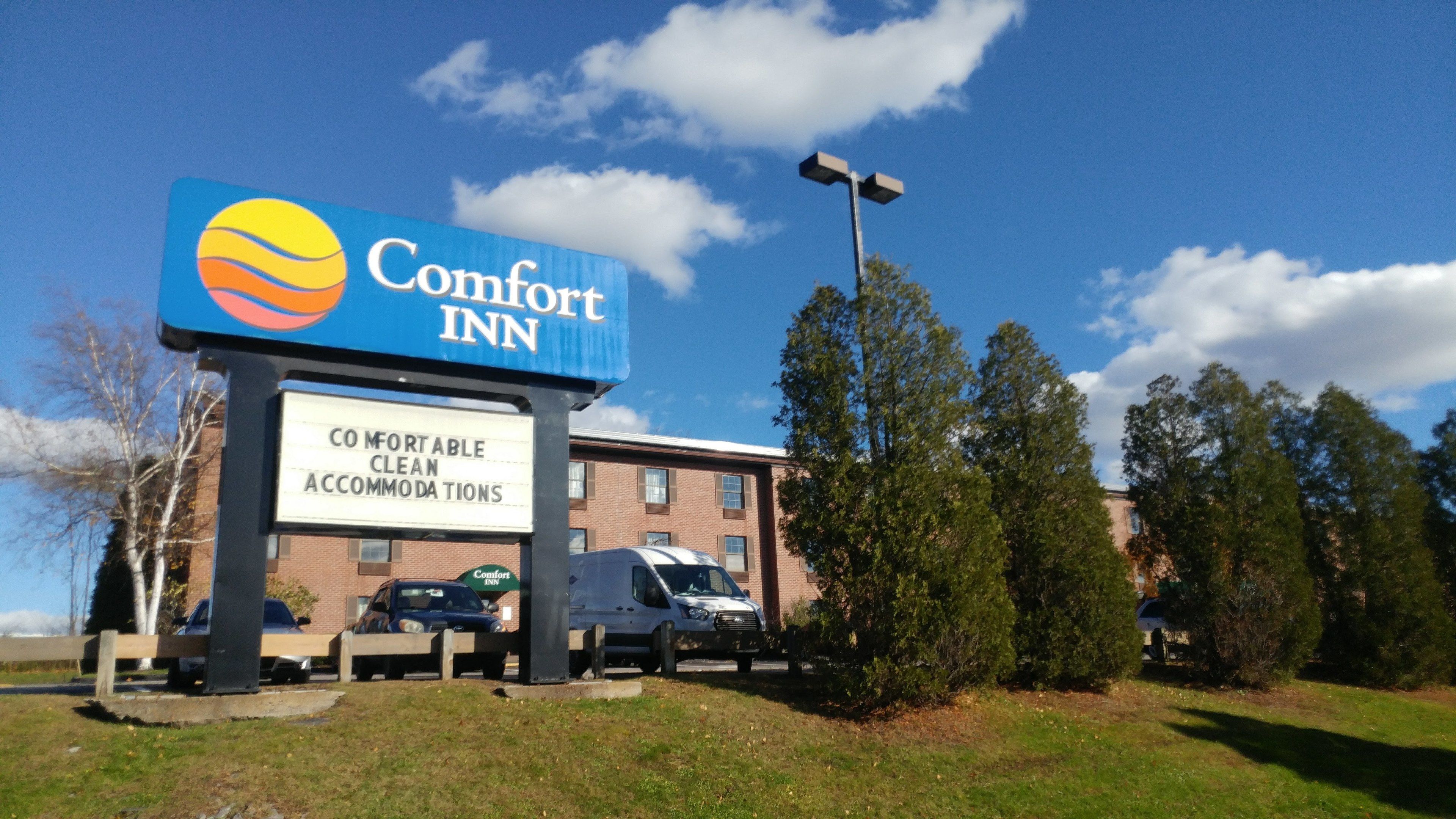 Placa do Comfort Inn, com boa visibilidade do edifício e carros estacionados.