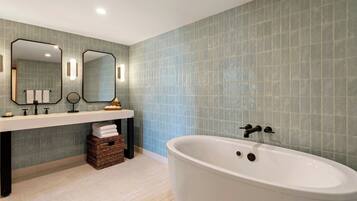 A modern bathroom with a freestanding bathtub, a double sink vanity, and a large mirror.