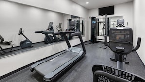 Ein modernes Fitnessstudio mit Laufbändern, Crosstrainern und Gewichten.