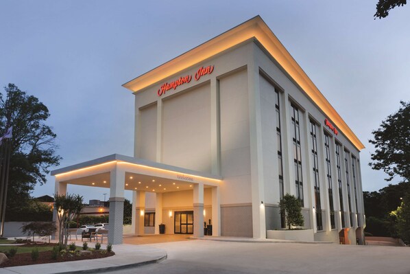 A Hampton Inn hotel with a modern facade, a covered entrance, and a landscaped driveway.
