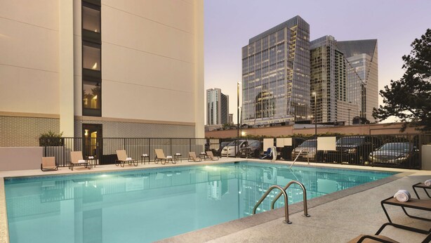 A swimming pool with lounge chairs and a view of tall buildings in the background. - Hampton Inn Atlanta Buckhead (Atlanta)