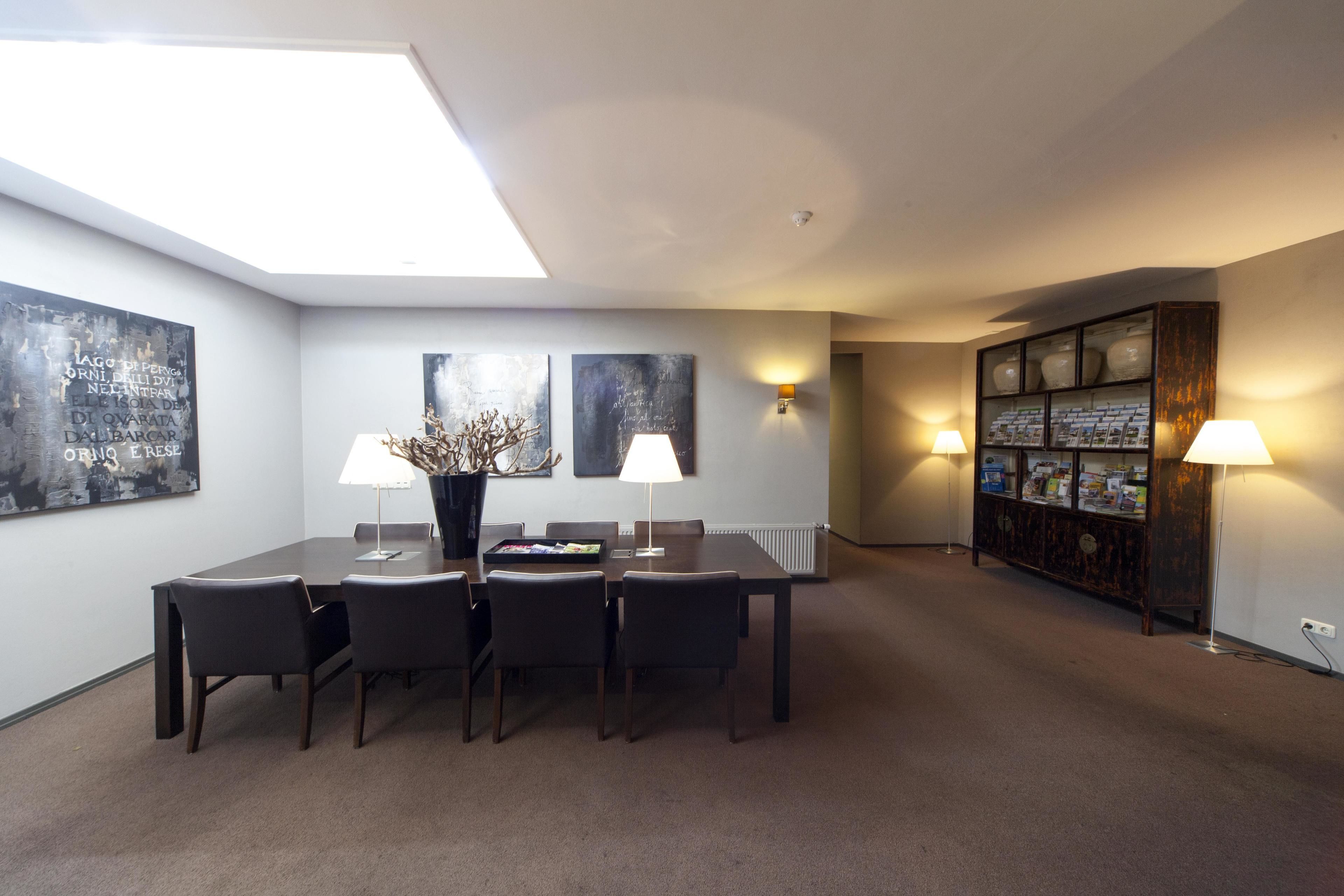 A dining area with a table, chairs, and two wall-mounted lamps.