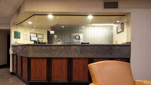A reception desk with a 'Quality' sign, a computer, and a leather chair.