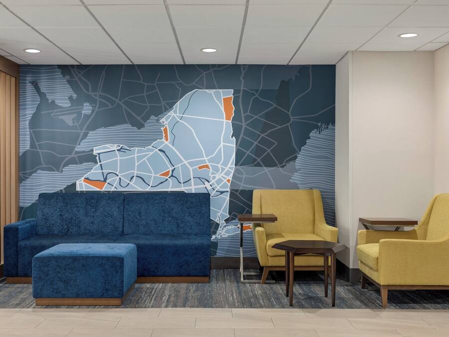 A lobby with a blue sofa, a yellow armchair, and a small table.