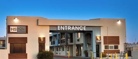 A hotel entrance with a sign reading "HOTEL SEVILLE" and "ENTRANCE" above the door.