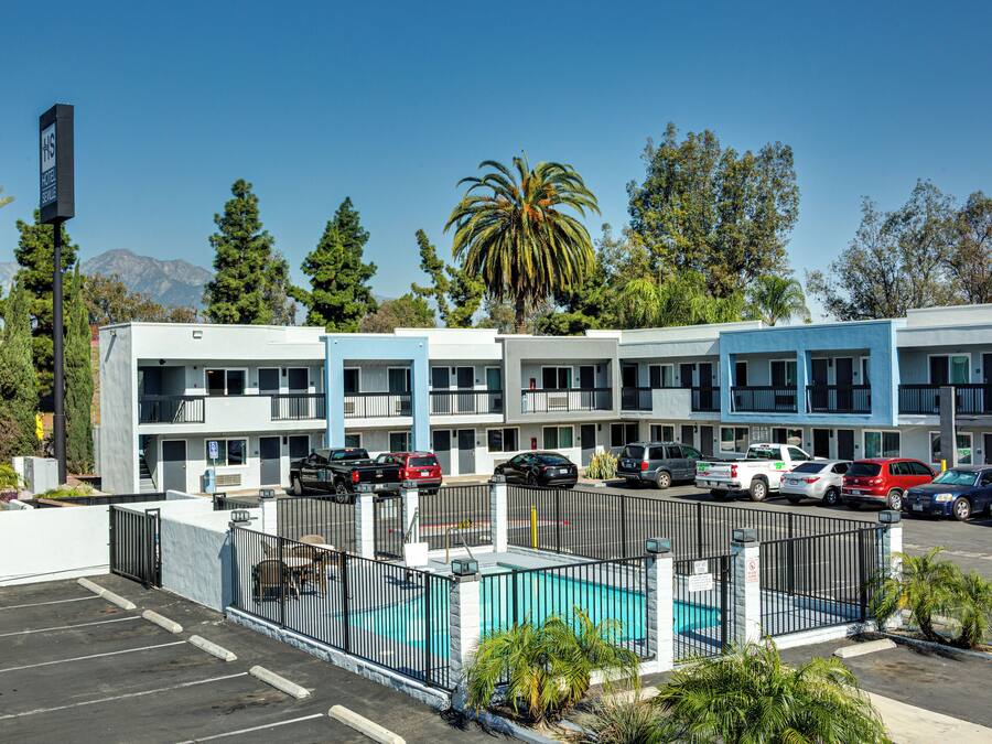 Un hotel de varios pisos con piscina, estacionamiento y vistas a las montañas.