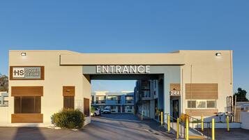 An entrance to a hotel with a clear sign, a parking area, and a building number 2441.