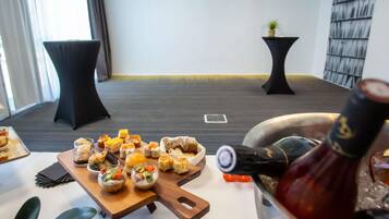 Una habitación con una mesa de comedor dispuesta con diversos bocadillos y una botella de vino.
