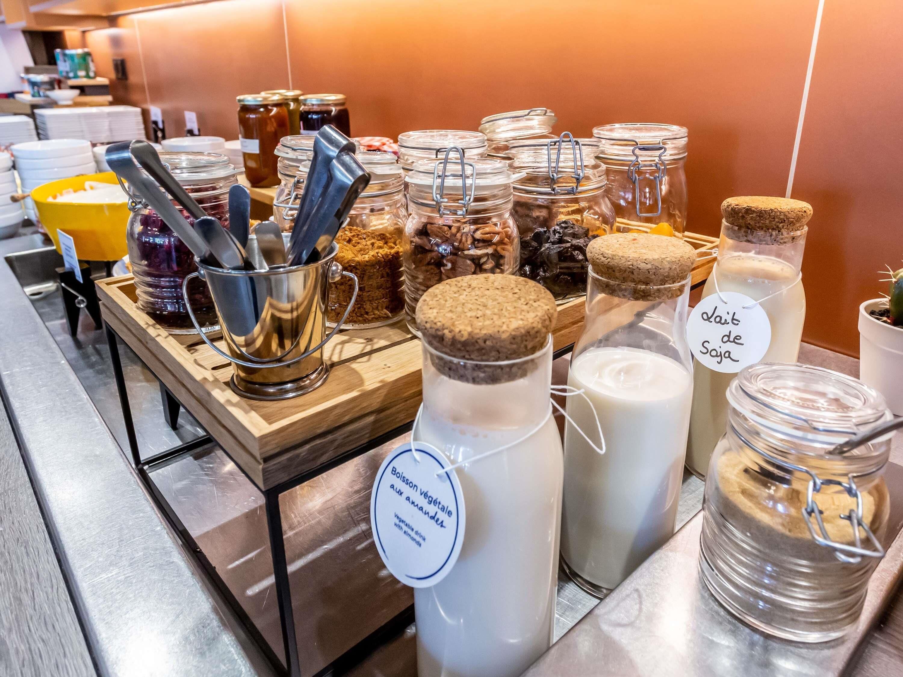 A buffet area with various food items and condiments.