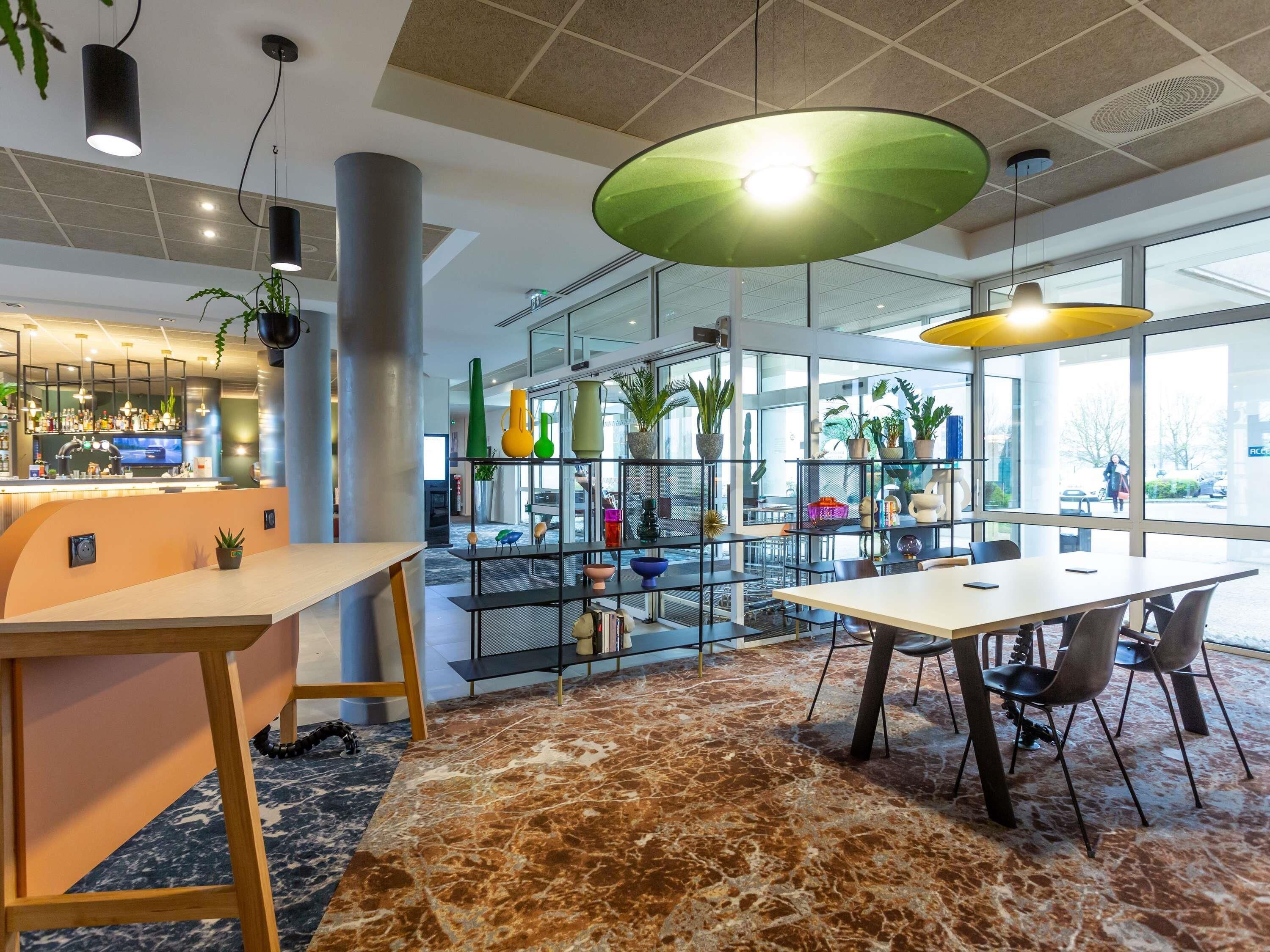 A modern interior with a bar area, seating, and a plant display.