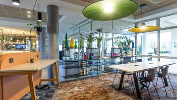 A modern interior with a bar area, seating, and a plant display.