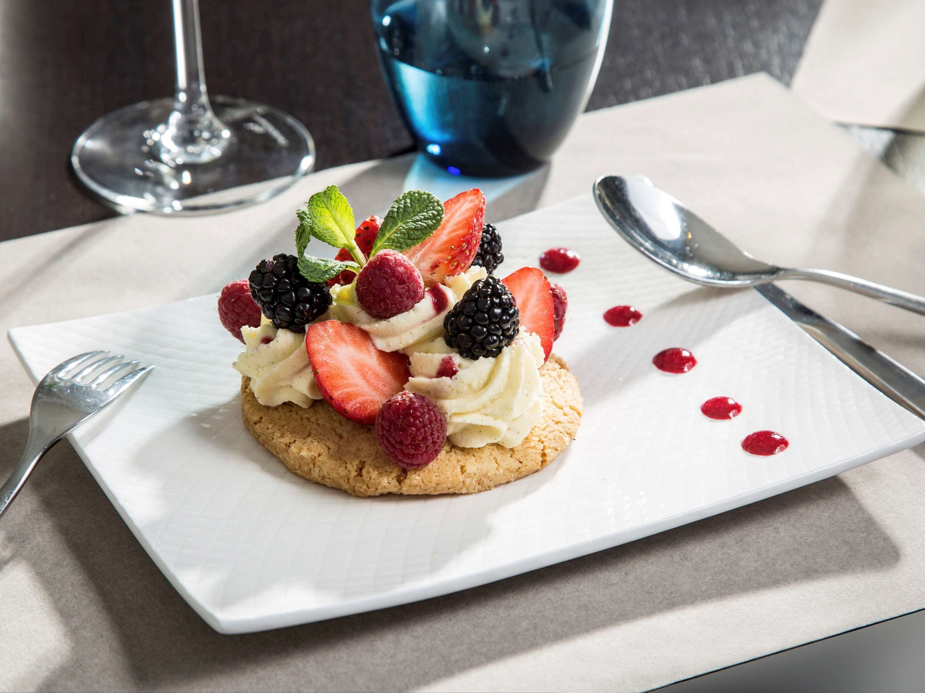 A dessert on a white plate with a fork and spoon beside it.