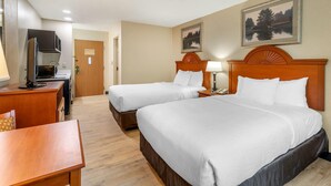 A hotel room with two beds, a desk, a TV, and a painting on the wall.
