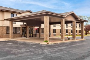 A two-story hotel with a covered entrance, brick facade, and a parking lot. - Econo Lodge Inn & Suites Oconto (Oconto)
